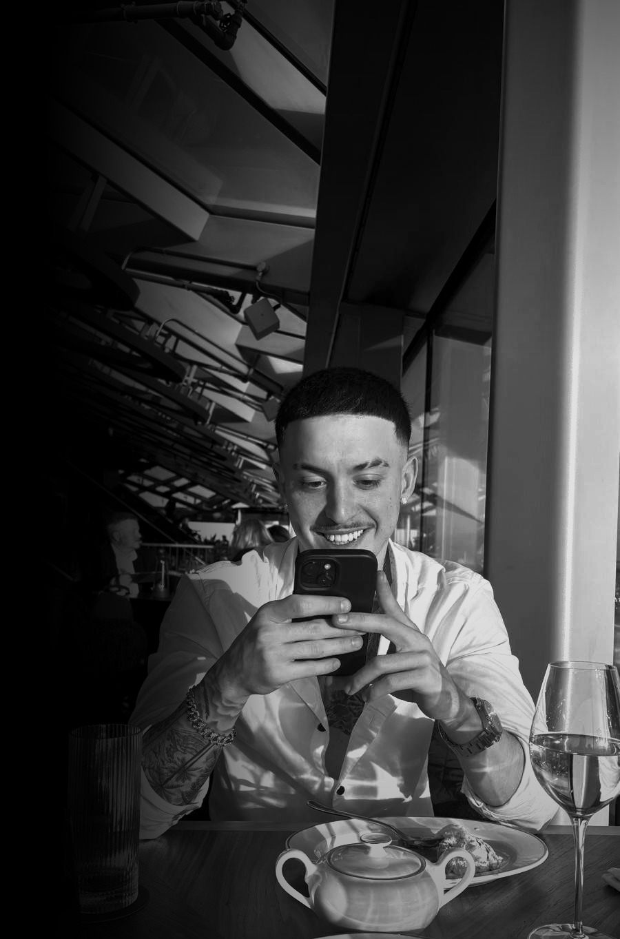 Barbero perfilando un corte con peine y tijera bajo luz natural tenue